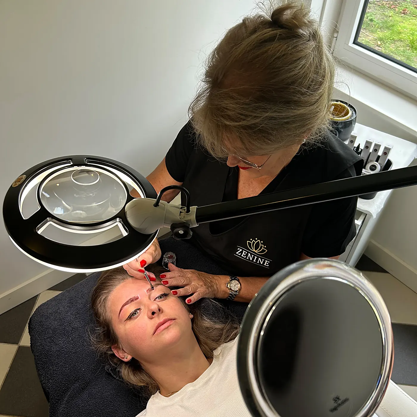 Ine Schrijver werkt onder de loeplamp de hybrid geverfde wenkbrauwen van een klant bij in salon Zenine