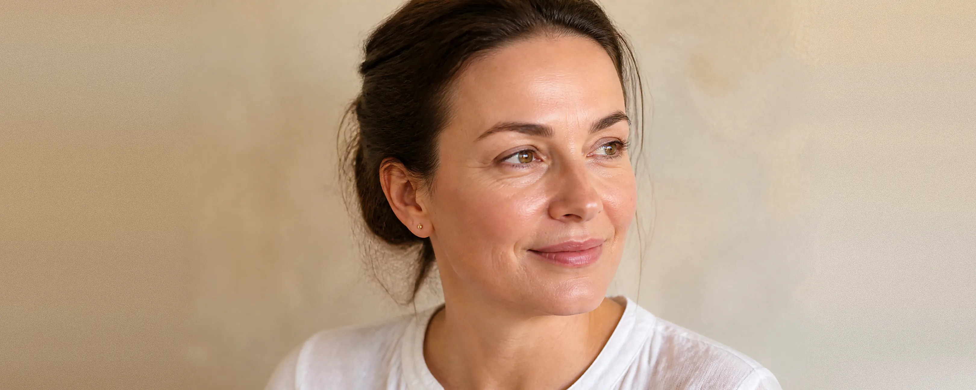 Vrouw met netjes gevormde wenkbrauwen en een gladde bovenlip kijkt rustig opzij