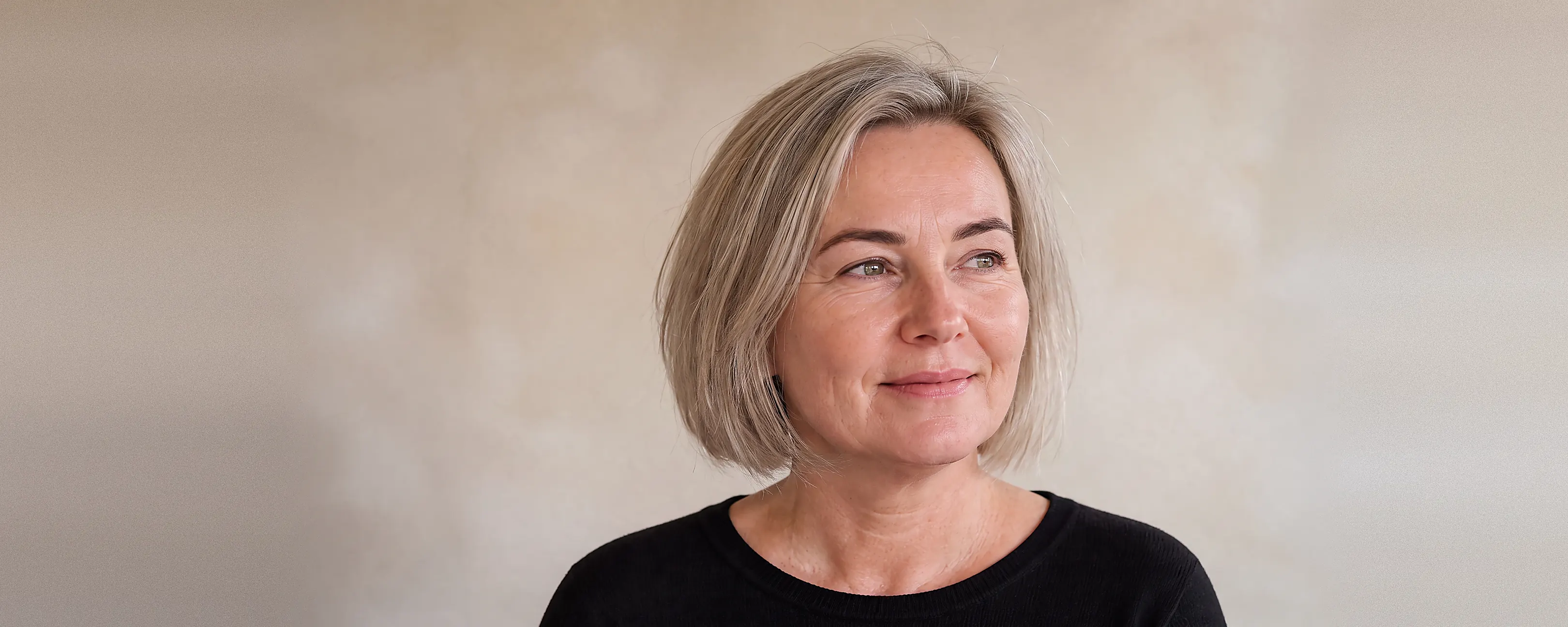 Vrouw met volle, zacht gedefinieerde wenkbrauwen kijkt rustig opzij