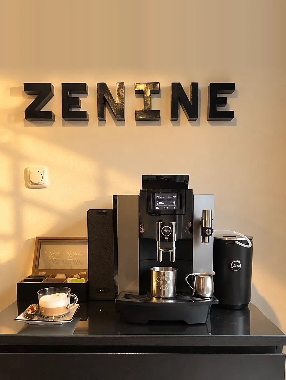 De koffiehoek van Zenine met het logo aan de muur